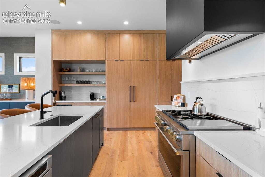 Image 5 of 38: Monogram range framed by white oak cabinetry and clean-lined finishes.
