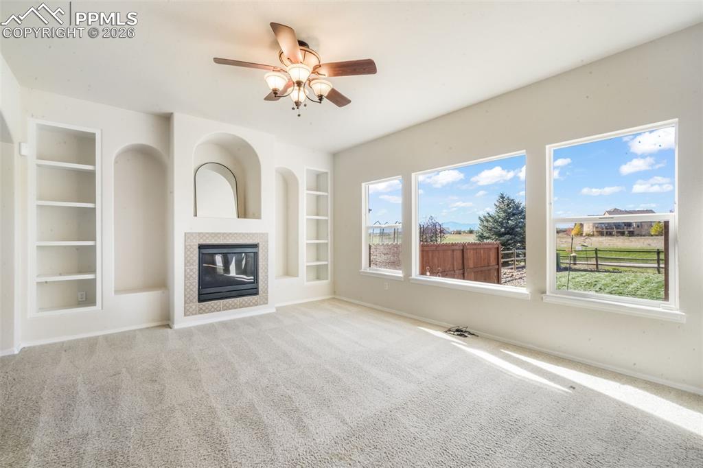 Image 11 of 50: Kitchen featuring tile countertops, a center island, light wood-style floor