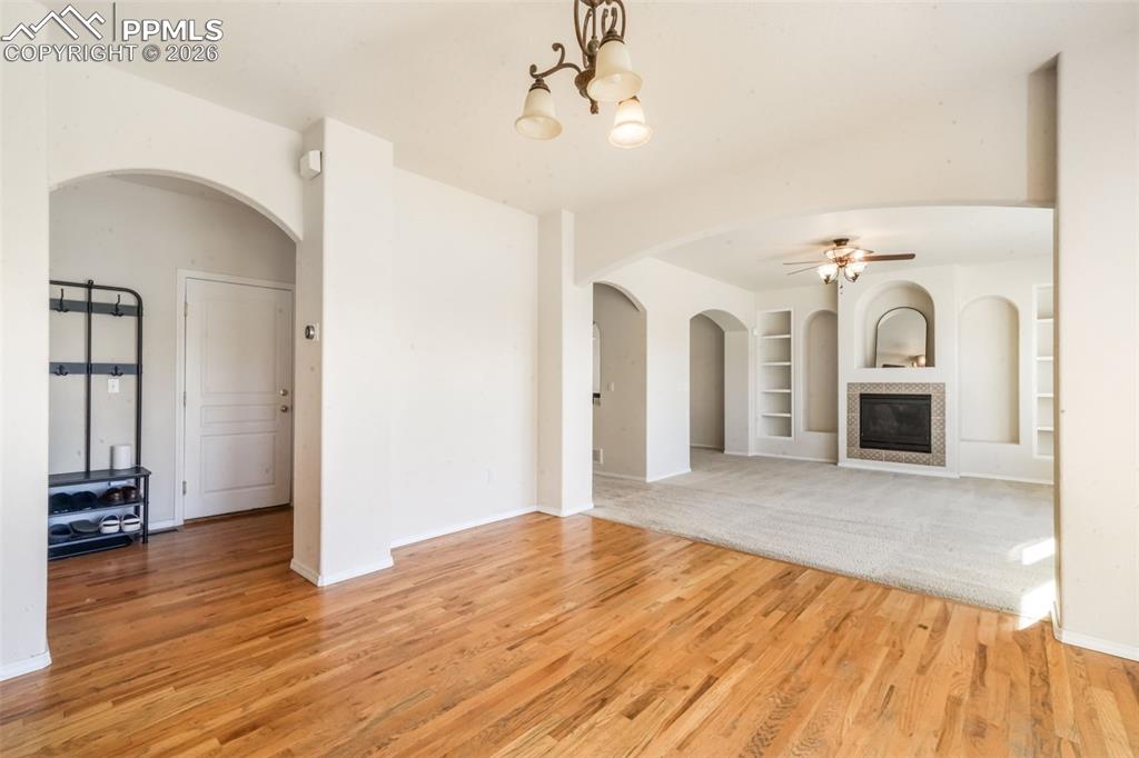 Image 9 of 50: Kitchen featuring light brown cabinets, arched walkways, a center island, a