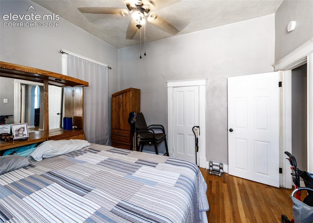 Image 12 of 25: Hardwood flooring, painted walls, ceiling fan with light fixture, and white