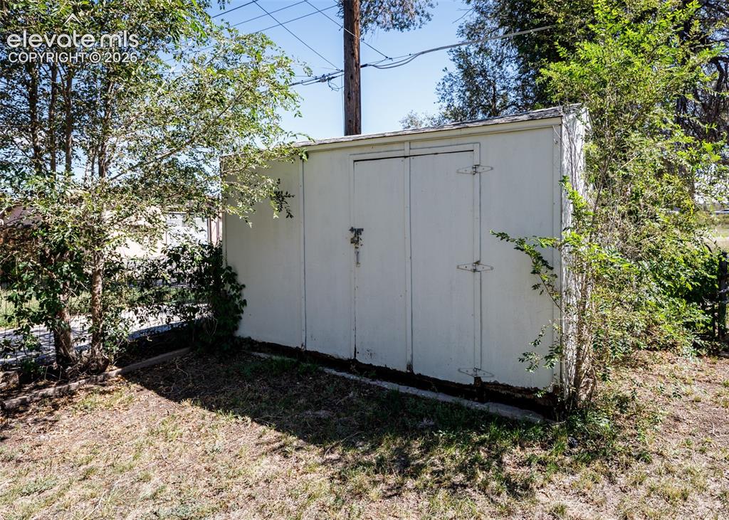 Image 23 of 25: Outdoor storage shed with double doors and hinge hardware