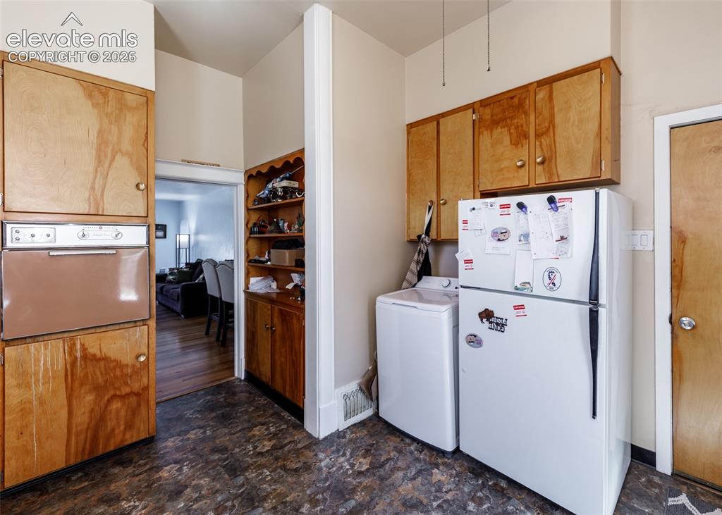Image 7 of 25: Built-in wall oven with wood cabinetry and complementary upper cabinetry