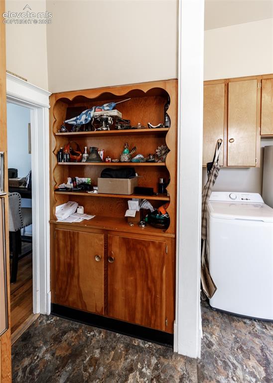 Image 8 of 25: Built-in cabinetry with open shelving and lower storage, textured flooring,
