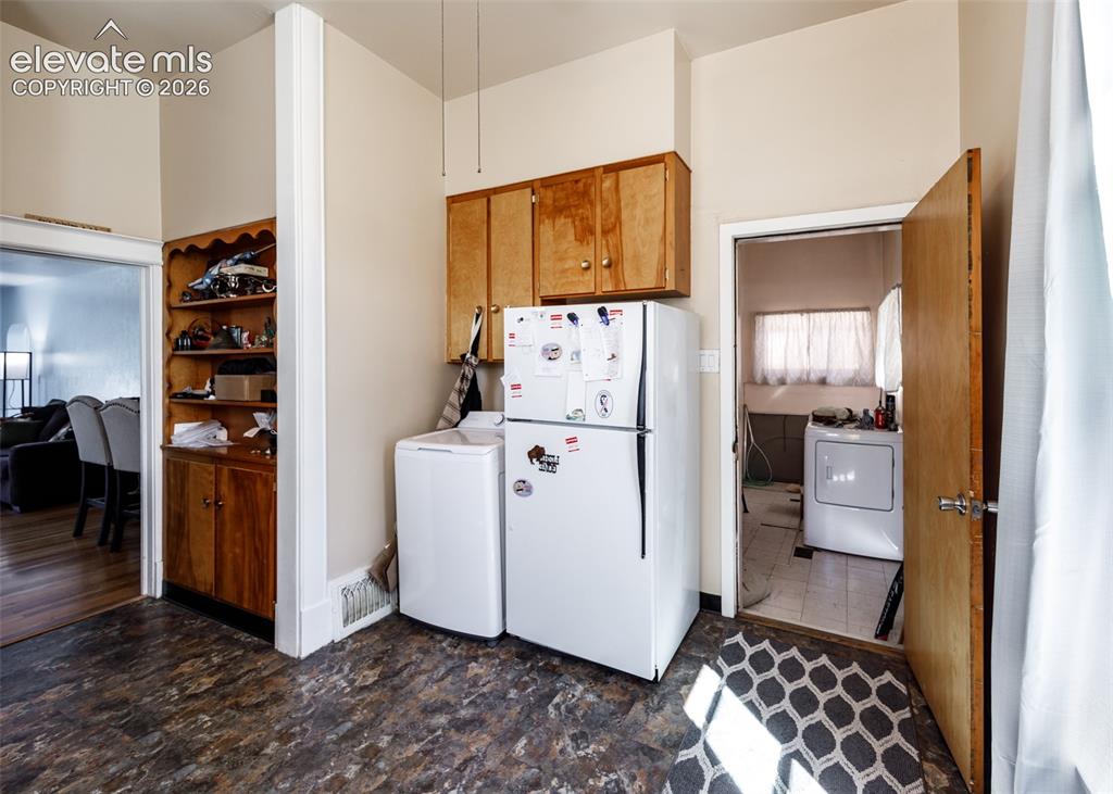 Image 9 of 25: Built-in wood cabinetry, wood-finish flooring, and white appliances