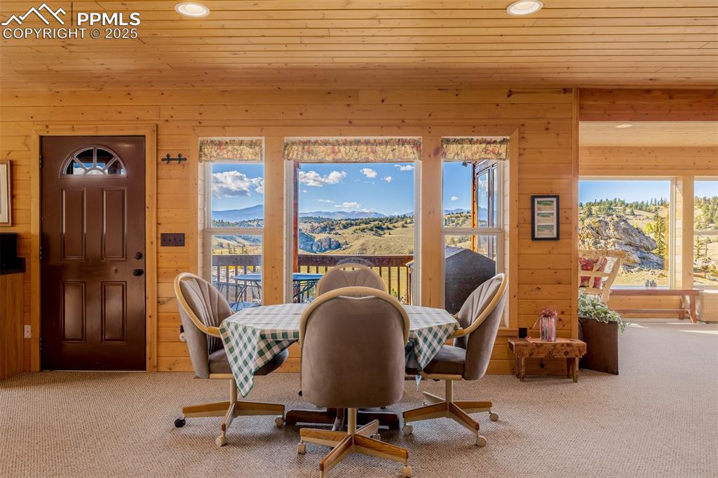 Image 15 of 48: Dining room featuring wooden walls, carpet floors, a mountain view, recesse