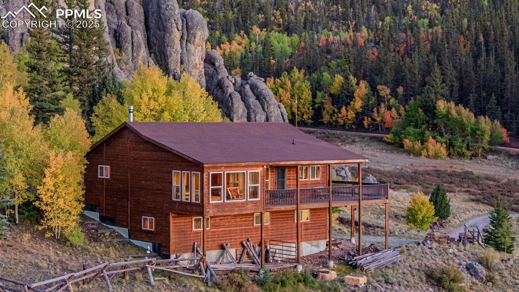 Image 47 of 48: Rear view of property featuring a deck and a forest view
