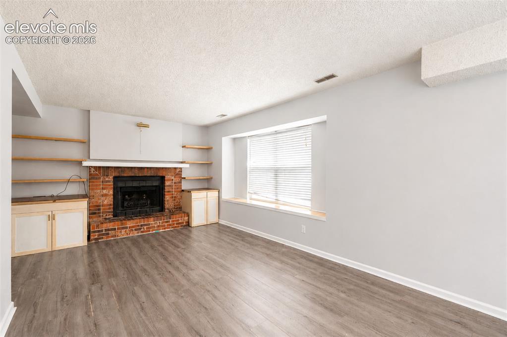 Image 29 of 35: Family Room with Window to Backyard and Fireplace.