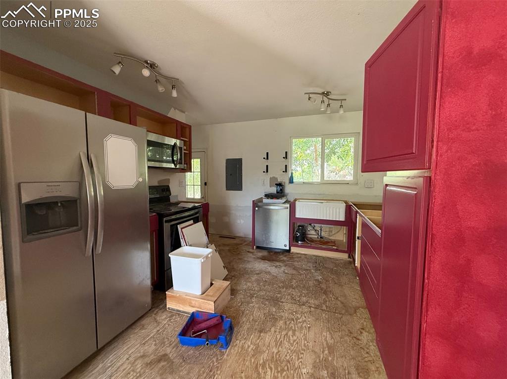 Image 4 of 10: Kitchen with appliances with stainless steel finishes and electric panel
