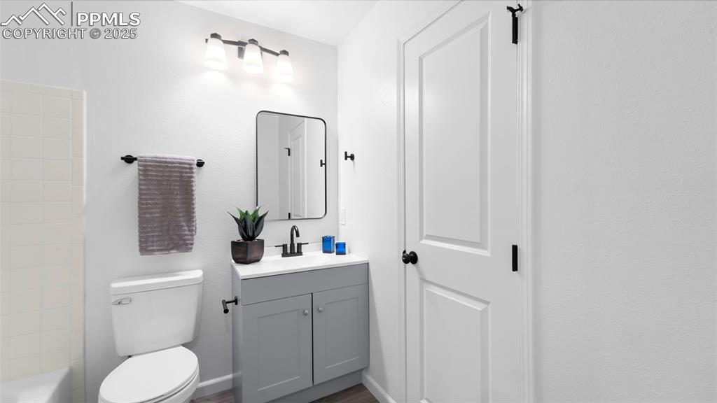 Image 14 of 21: Full bath featuring vanity, dark wood finished floors, and shower / bath co