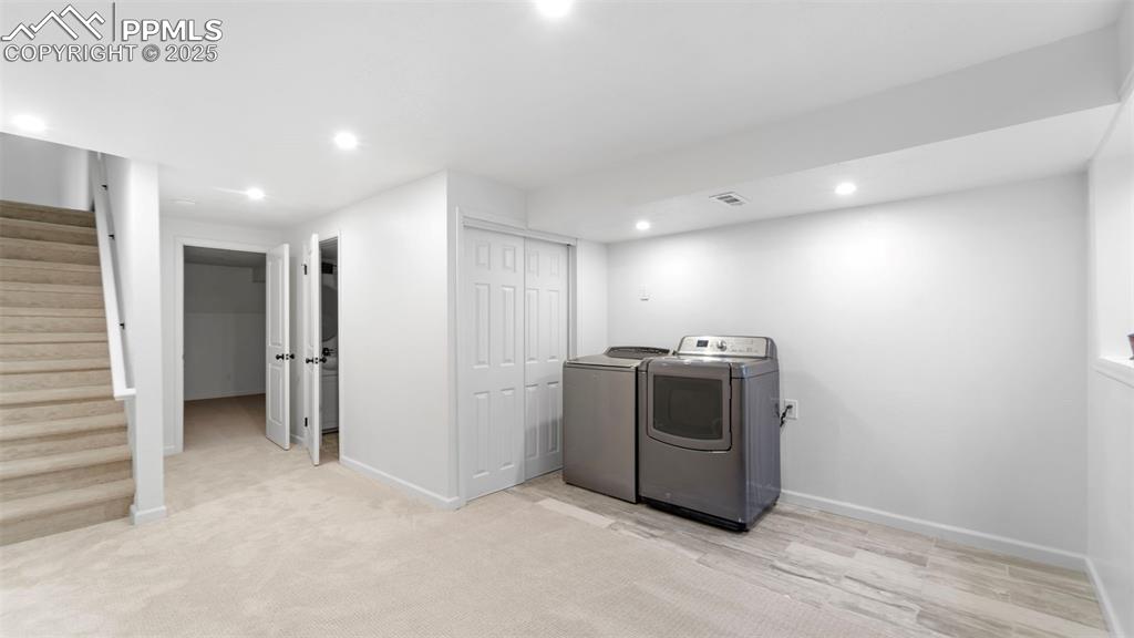 Image 18 of 21: Washroom featuring recessed lighting, washer and clothes dryer, light wood-