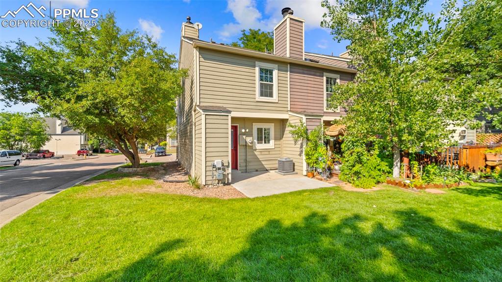 Image 21 of 21: Back of house with a lawn, a chimney, and a patio