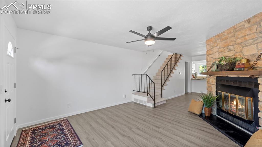 Image 5 of 21: Entryway featuring wood finished floors, a fireplace, and stairway