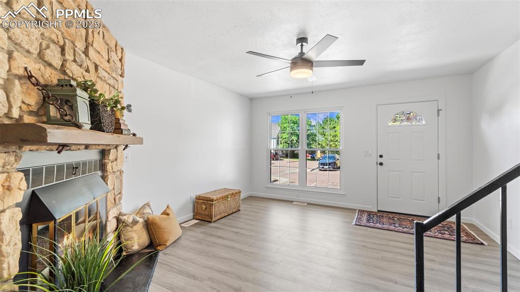 Image 6 of 21: Foyer featuring wood finished floors, a fireplace, a textured ceiling, and 