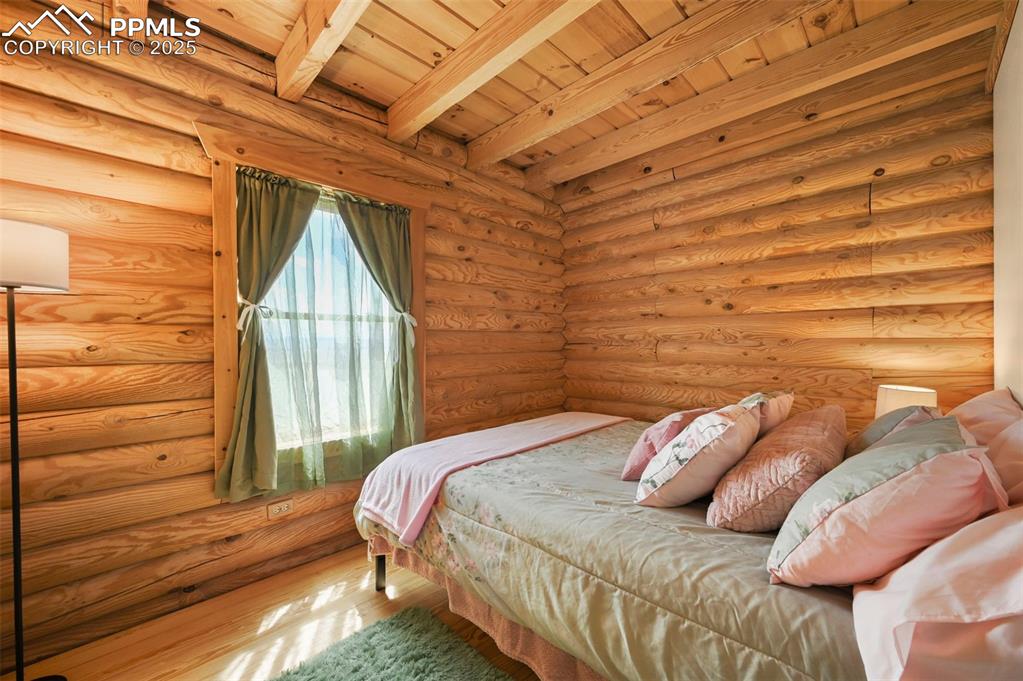Image 12 of 35: Bedroom featuring wood finished floors, a wood ceiling with exposed beams, 