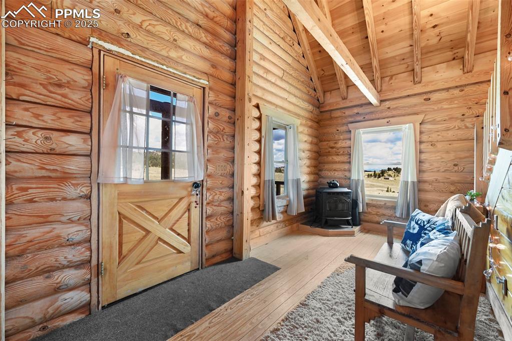 Image 5 of 35: Entrance foyer featuring a wood stove, wood ceiling, hardwood / wood-style 