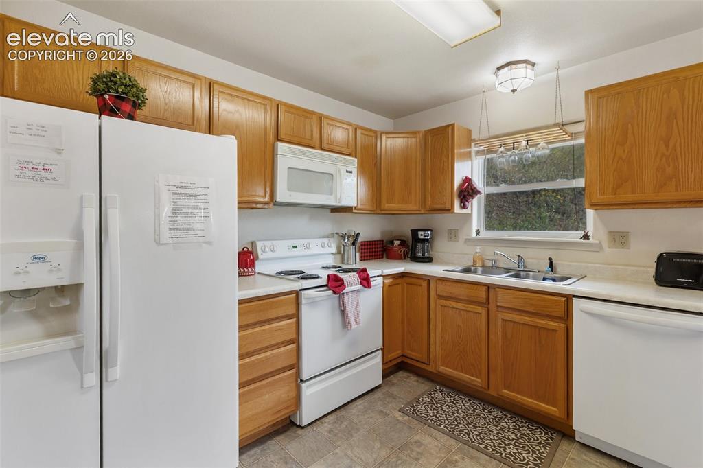 Image 19 of 36: Clean and crisp white appliances make this an open and bright space. 