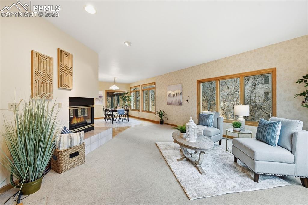 Image 11 of 49: Carpeted living room featuring a tiled fireplace and wallpapered walls