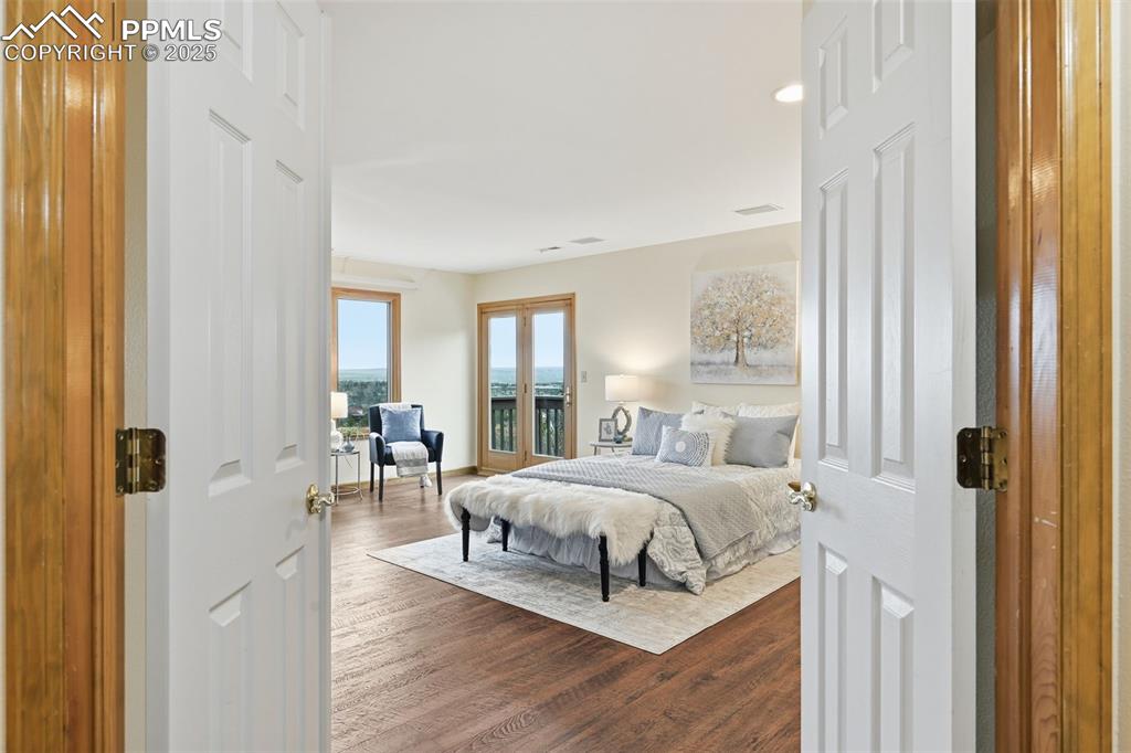 Image 22 of 49: Bedroom with access to outside, wood finished floors, and recessed lighting