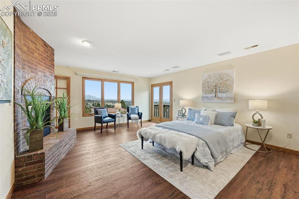 Image 23 of 49: Bedroom with wood finished floors and access to exterior