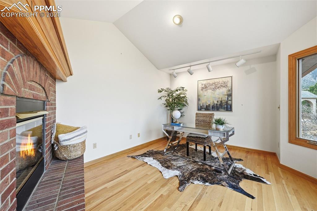 Image 25 of 49: Office area featuring lofted ceiling, light wood-style flooring, track ligh