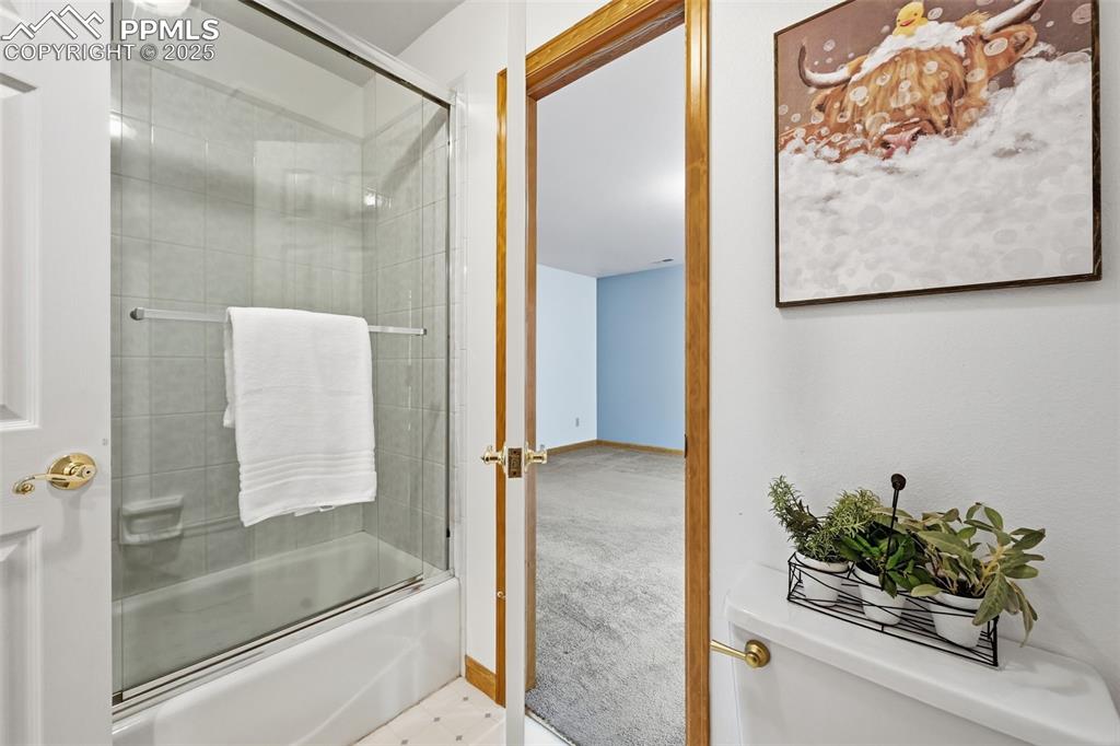 Image 31 of 49: Full bathroom featuring shower / bath combination with glass door and carpe