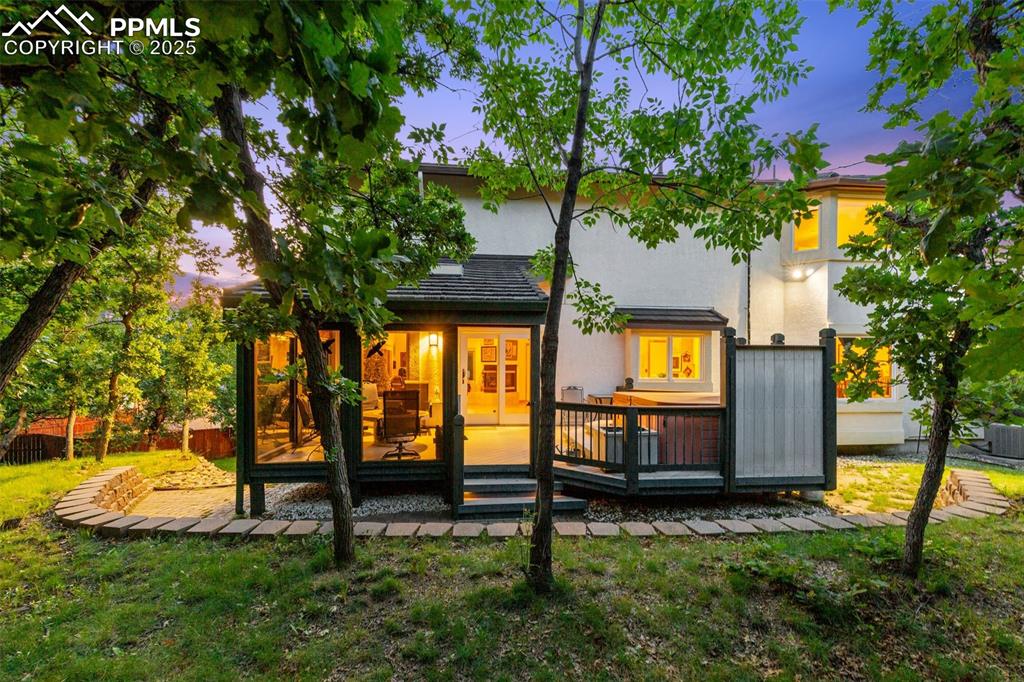 Image 9 of 49: Back of house with stucco siding and a wooden deck