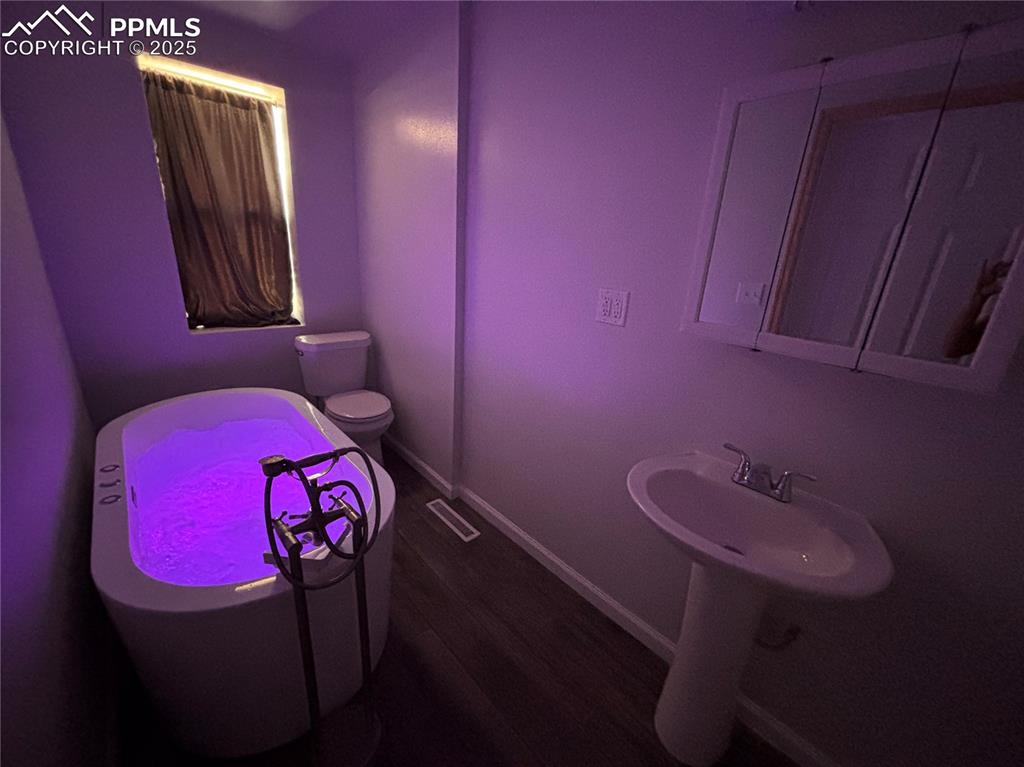 Image 18 of 35: Bathroom with baseboards and dark wood-style floors