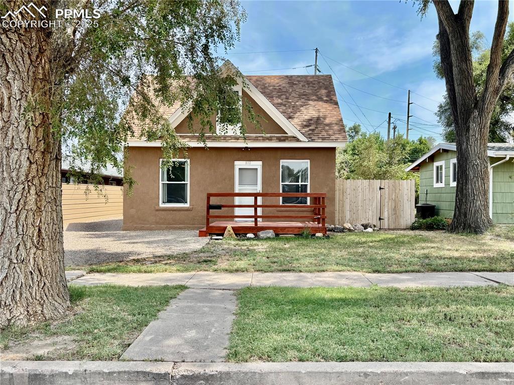 Image 2 of 35: View of front of property featuring a shingled roof, a wooden deck, and stu