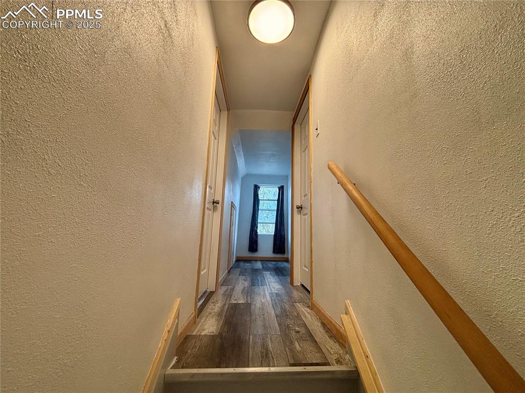 Image 22 of 35: Hall featuring a textured wall and dark wood-style floors