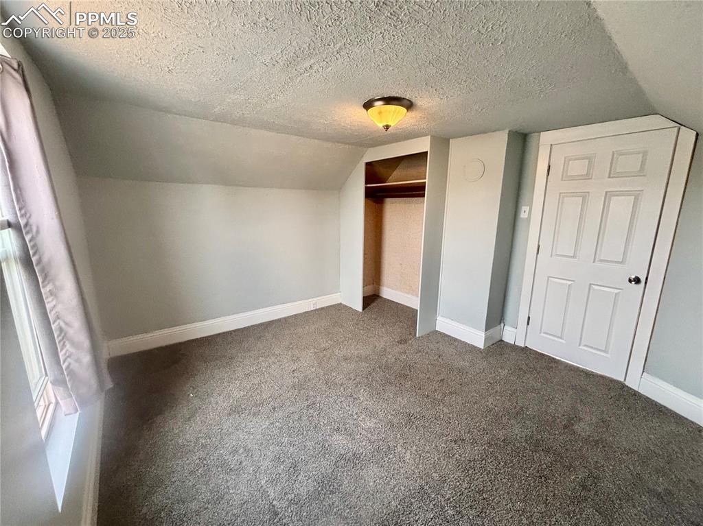 Image 26 of 35: Unfurnished bedroom featuring carpet flooring, a closet, a textured ceiling