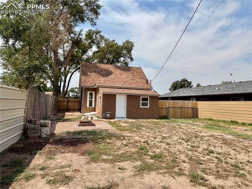 Image 28 of 35: Rear view of house featuring a patio, a fenced backyard, a shingled roof, a