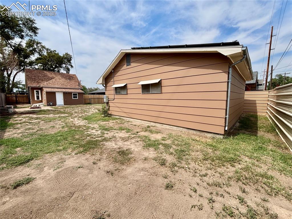 Image 35 of 35: View of side of property featuring a fenced backyard and an outbuilding