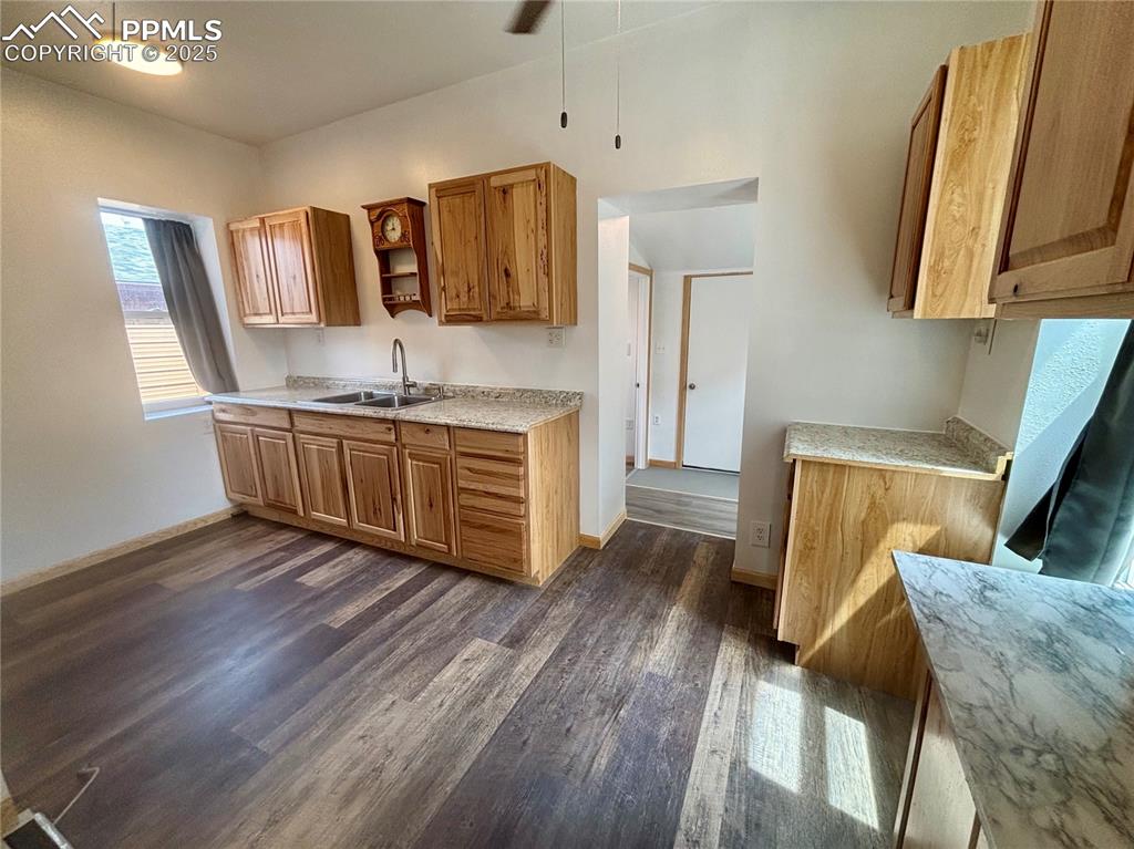 Image 9 of 35: Kitchen featuring dark wood-style floors, brown cabinetry, open shelves, an