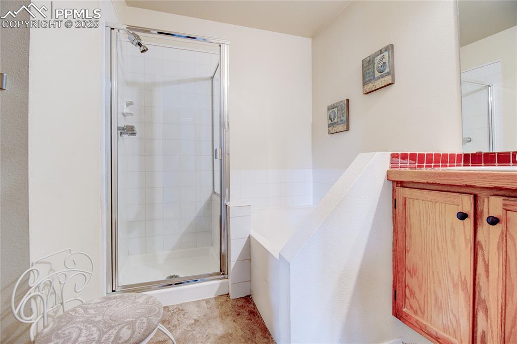 Image 20 of 32: Bathroom featuring a shower stall, a bath, and vanity