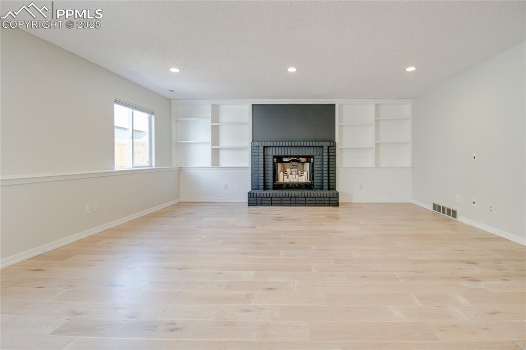 Image 21 of 32: Unfurnished living room with recessed lighting, light wood-style floors, a