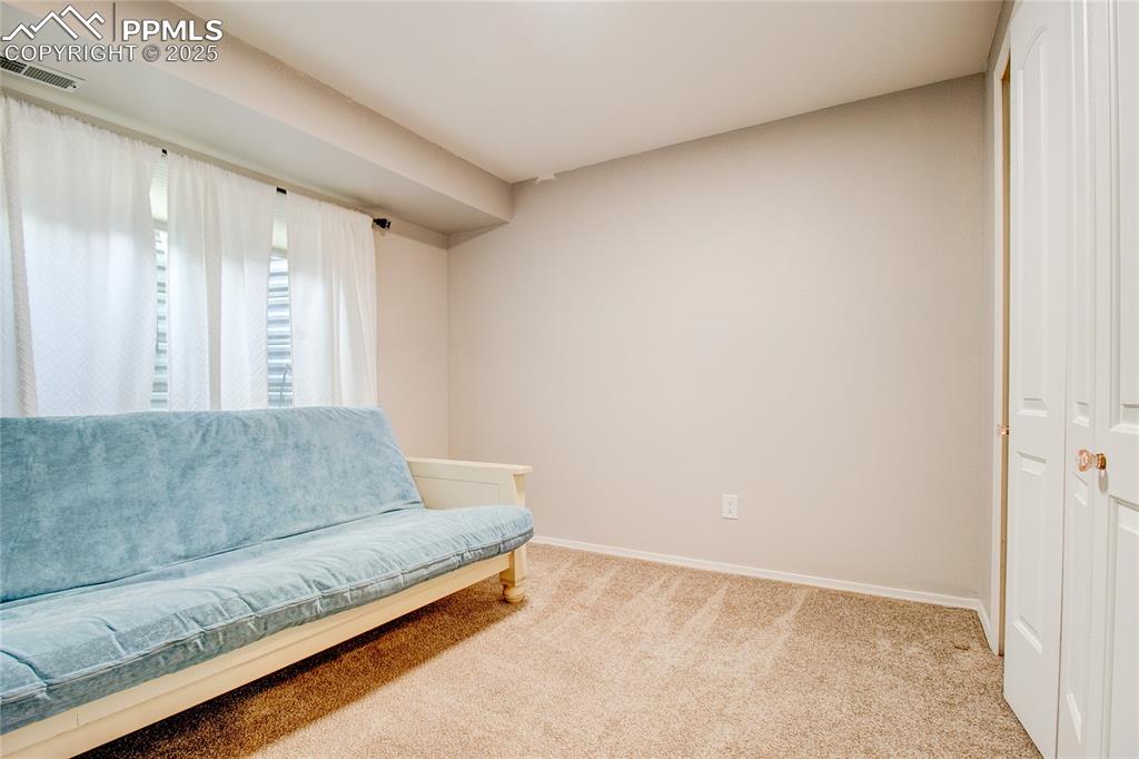 Image 27 of 32: Sitting room with carpet and baseboards