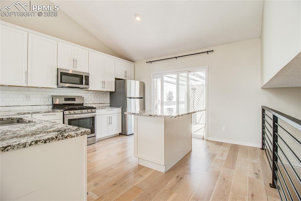 Image 9 of 32: Kitchen featuring stainless steel appliances, tasteful backsplash, light st