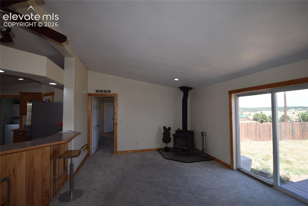 Image 11 of 48: Sliding glass doors, wood-paneled breakfast bar, vaulted ceilings, recessed