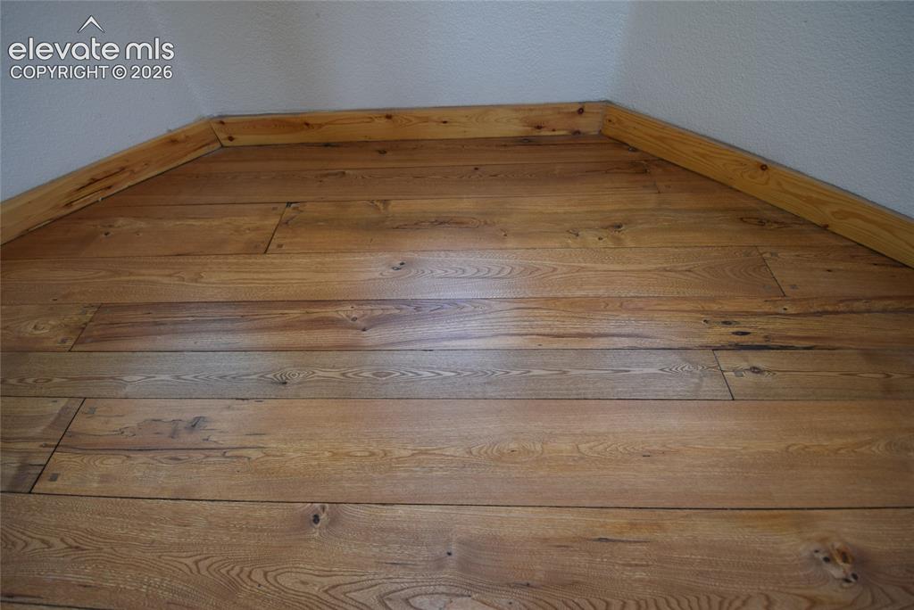 Image 18 of 48: Wood-finish flooring with natural graining and light-toned wood trim