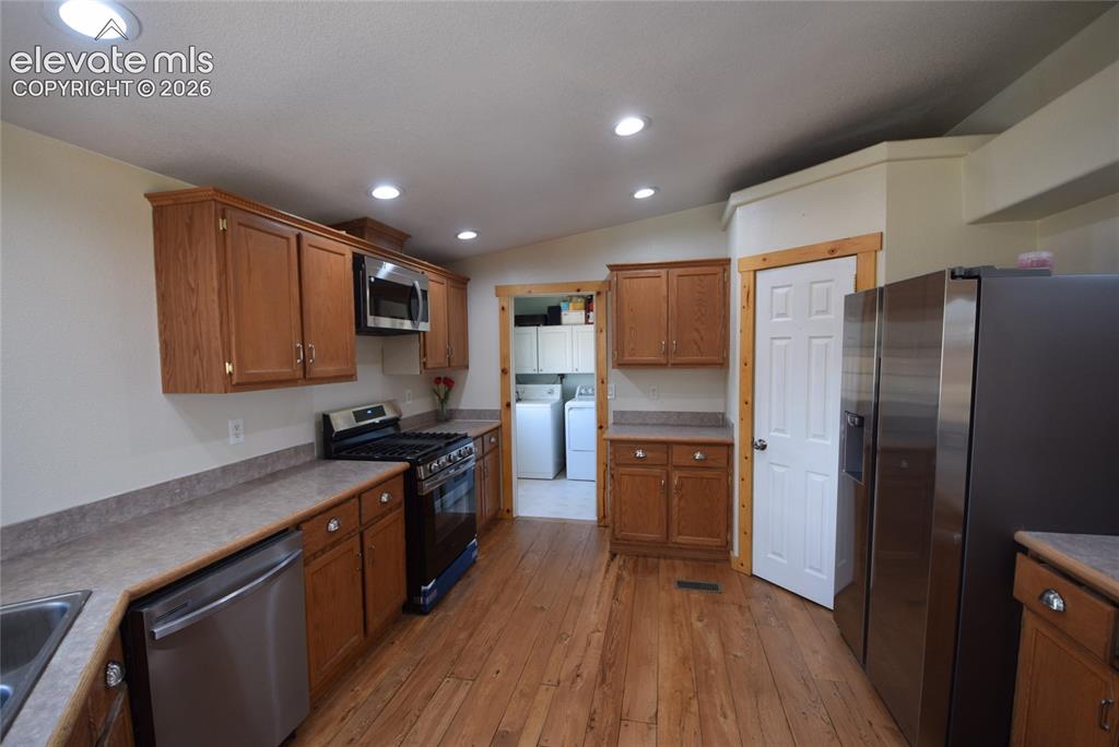 Image 23 of 48: Kitchen featuring wood-finish flooring, recessed lighting, wood cabinetry,