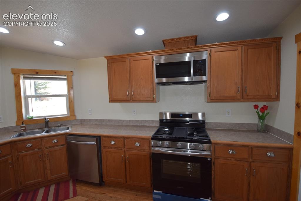 Image 24 of 48: Kitchen featuring recessed lighting, wood-finish cabinetry, stainless steel