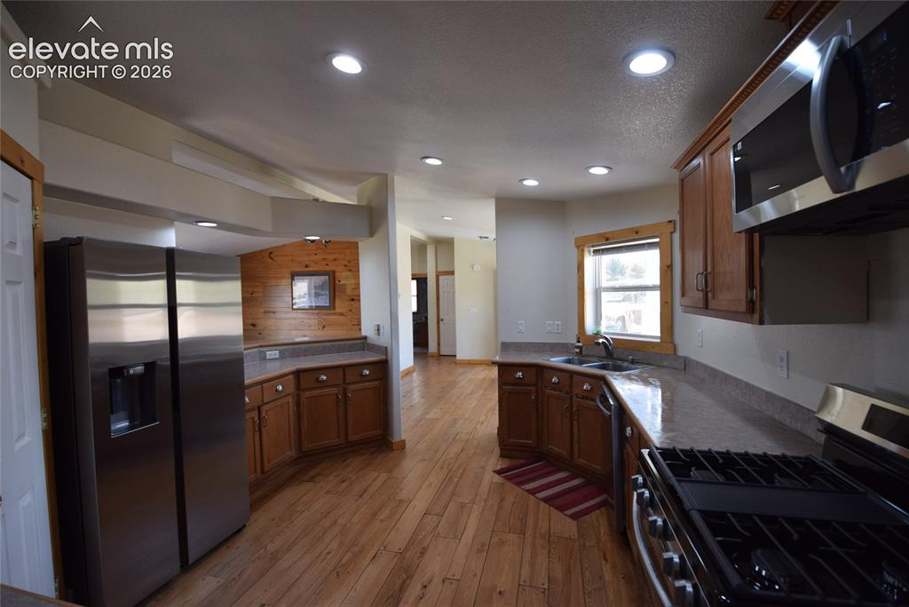 Image 25 of 48: Kitchen featuring wood-finish flooring, recessed lighting, wood cabinetry,