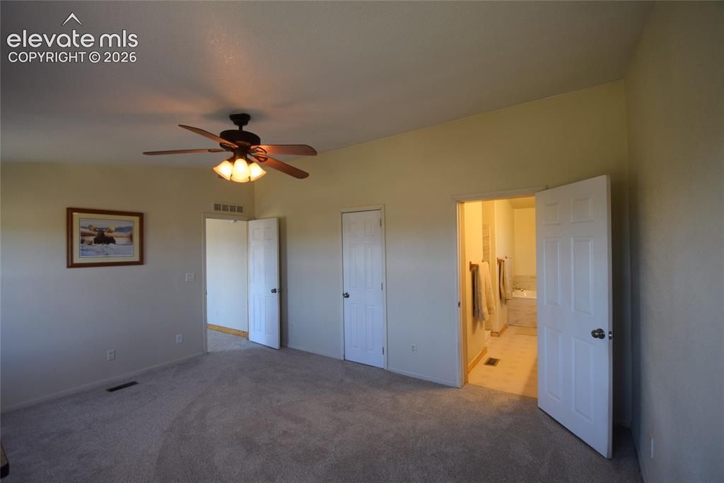 Image 29 of 48: Neutral-toned carpeting, ceiling fan with integrated lighting, and a white