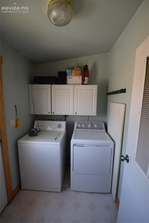Image 40 of 48: Laundry area featuring white cabinetry and light-toned flooring