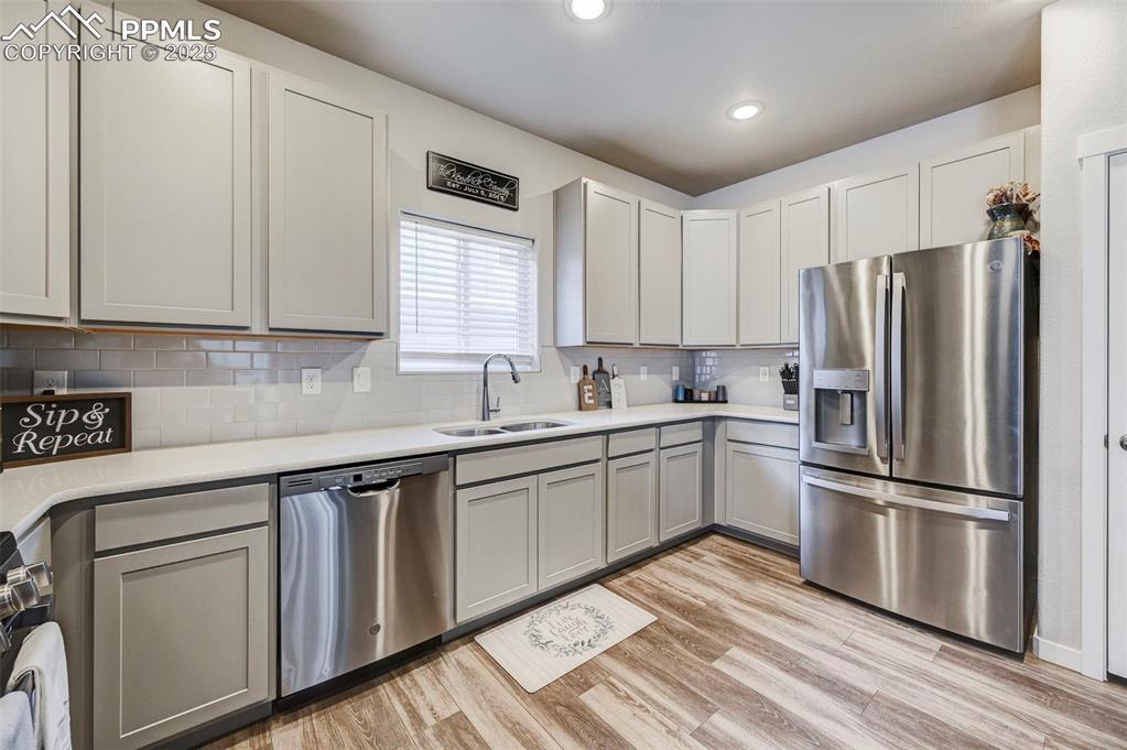 Image 21 of 46: Kitchen featuring appliances with stainless steel finishes, light wood-styl