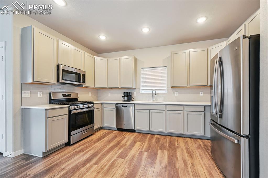 Image 24 of 46: Kitchen featuring stainless steel appliances, light wood-style flooring, de