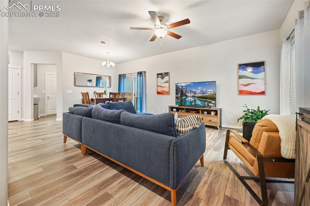 Image 26 of 46: Living area featuring light wood-style flooring, a chandelier, and ceiling