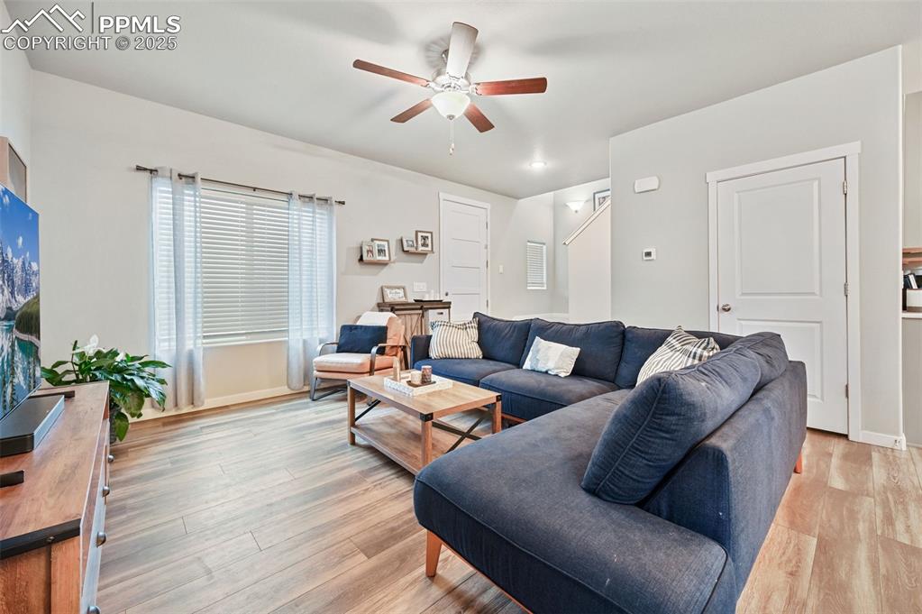 Image 27 of 46: Living area featuring light wood-style flooring and a ceiling fan