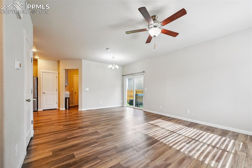 Image 28 of 46: Spare room with a chandelier, wood finished floors, a ceiling fan, and a sm