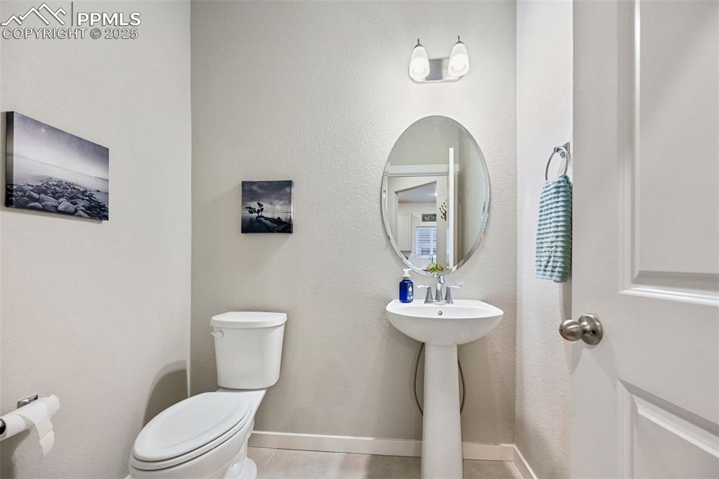 Image 33 of 46: Powder room on main level by mudroom and garage